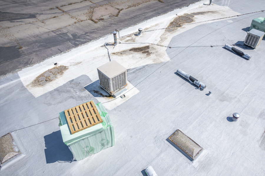 A commercial flat roof with signs of water pooling and dirt buildup