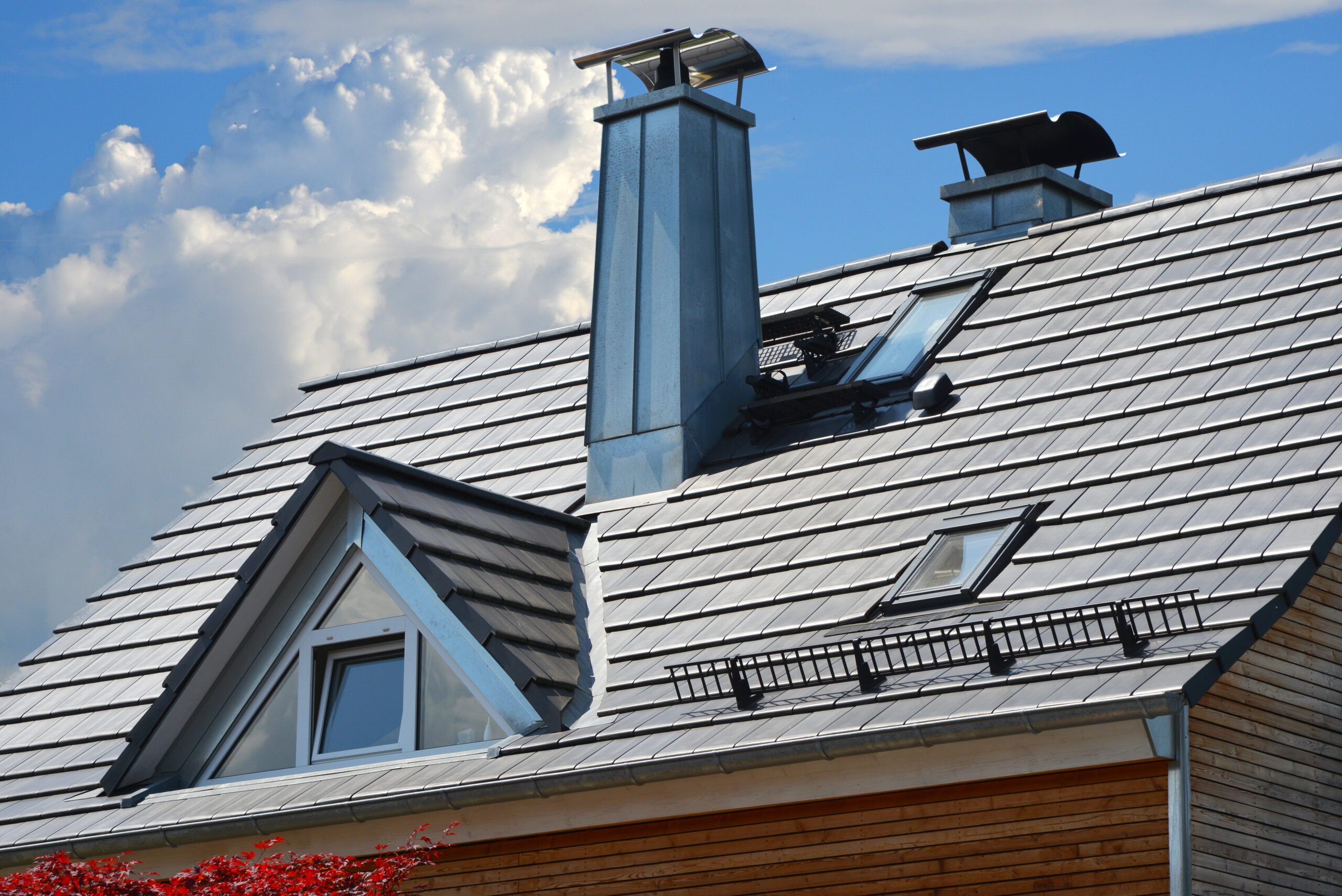 A modern residential roof with reflective metal shingles