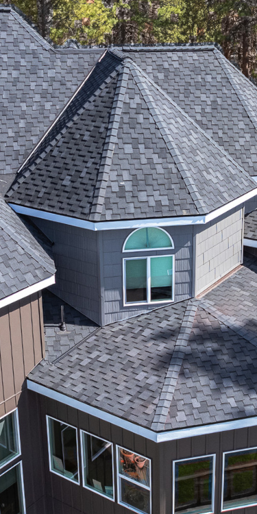 Multi-faceted gray Presidential shingle roof with distinctive pattern and a turret-style section.