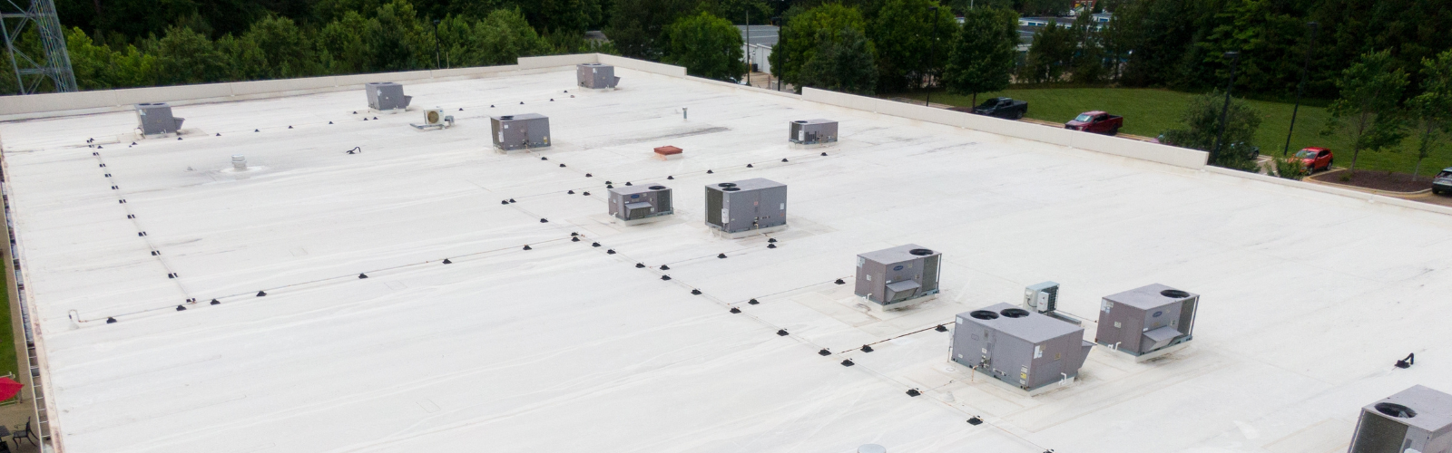 White single-ply commercial roof with multiple HVAC units on top, showcasing a clean and efficient membrane installation ideal for TPO or PVC roofing systems.