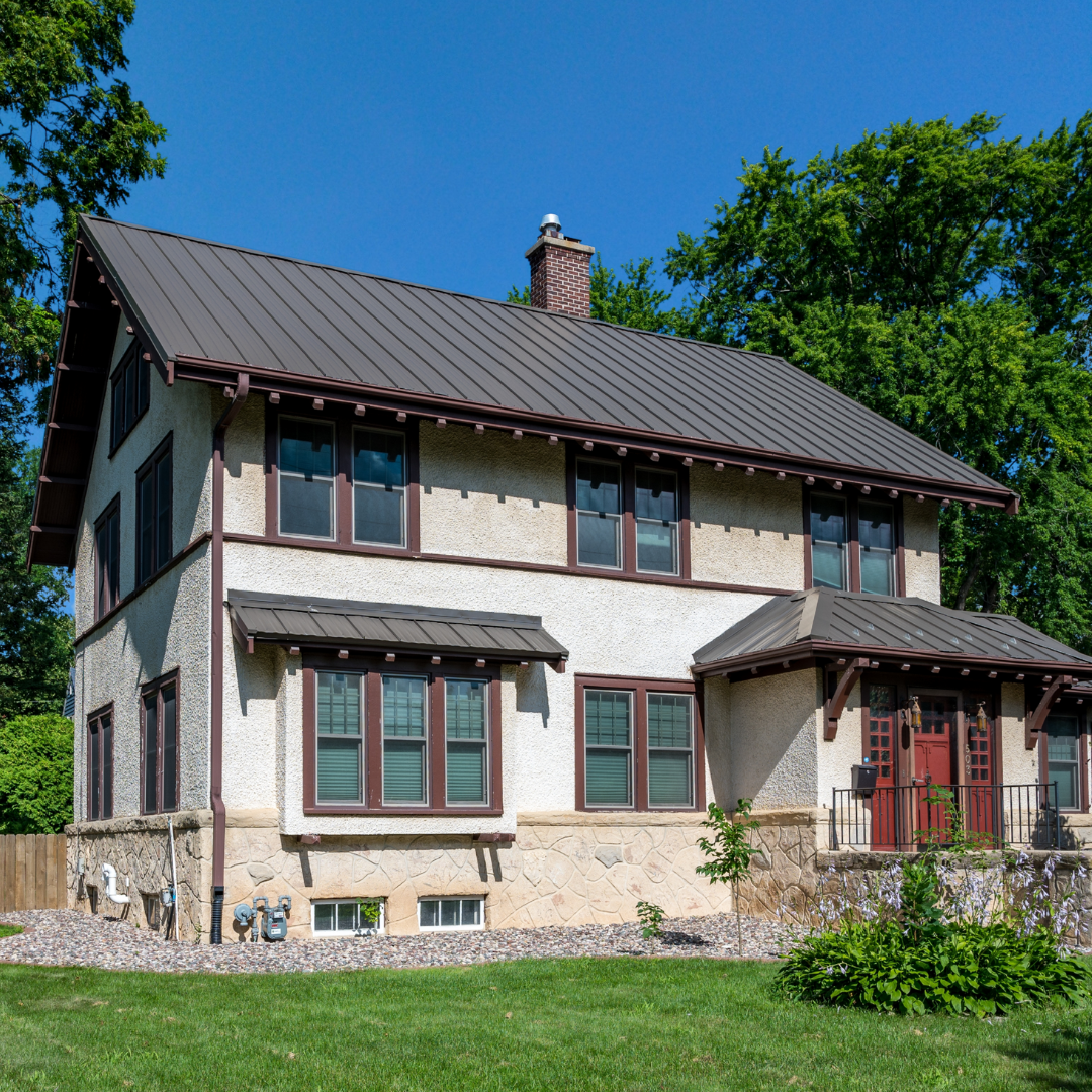Two-story home with sleek brown standing seam metal roofing and matching accents over windows and entry.